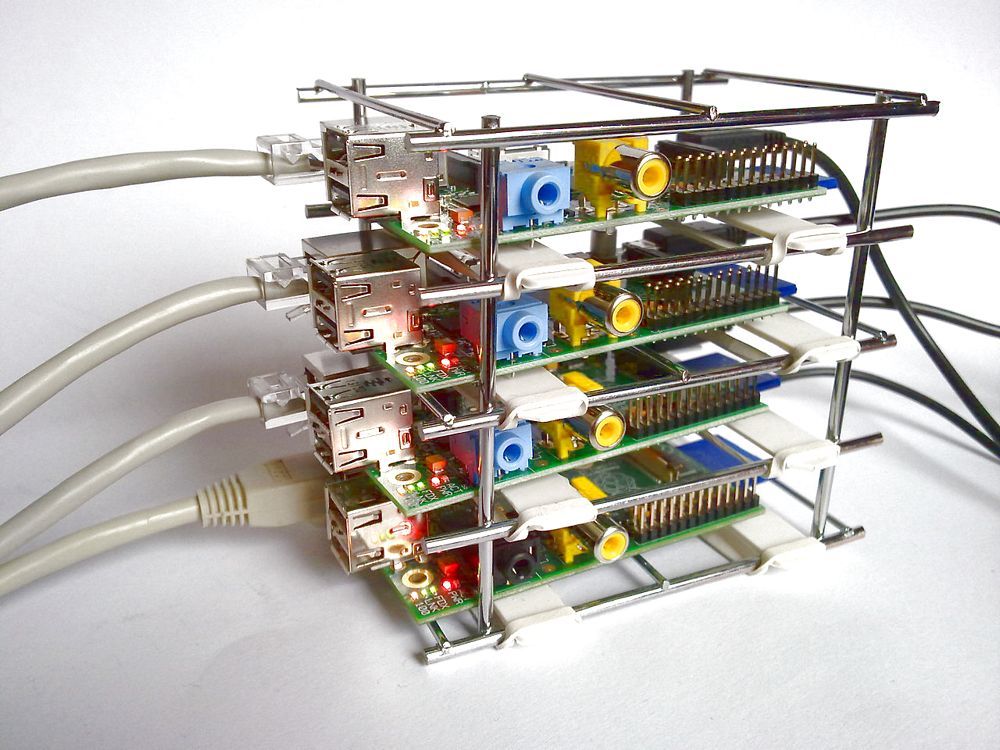 Four Raspberry Pi boards stacked in a metal frame and wired with Ethernet cables as a cluster