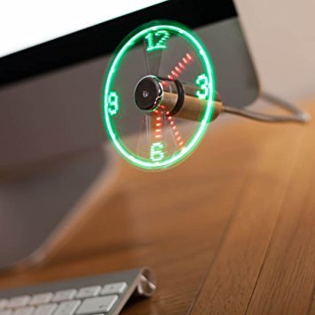 USB LED clock fan running beside a monitor, its spinning blades showing a glowing clock face